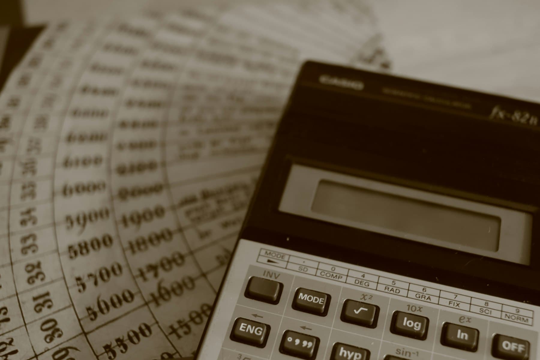 Calculator resting on printed spreadsheet columns of numbers