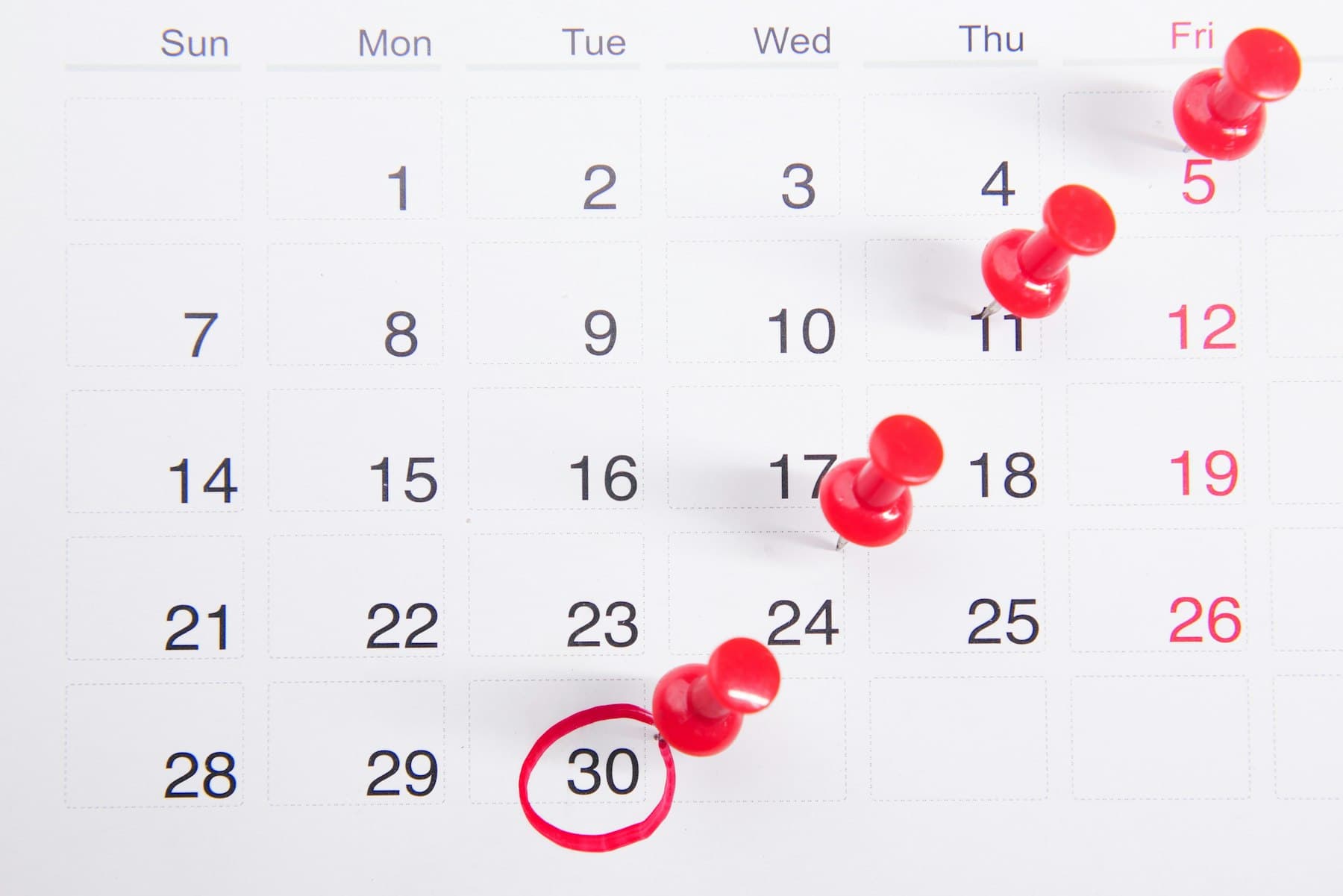 Monthly calendar with red marking pins highlighting an ascending sequence of dates
