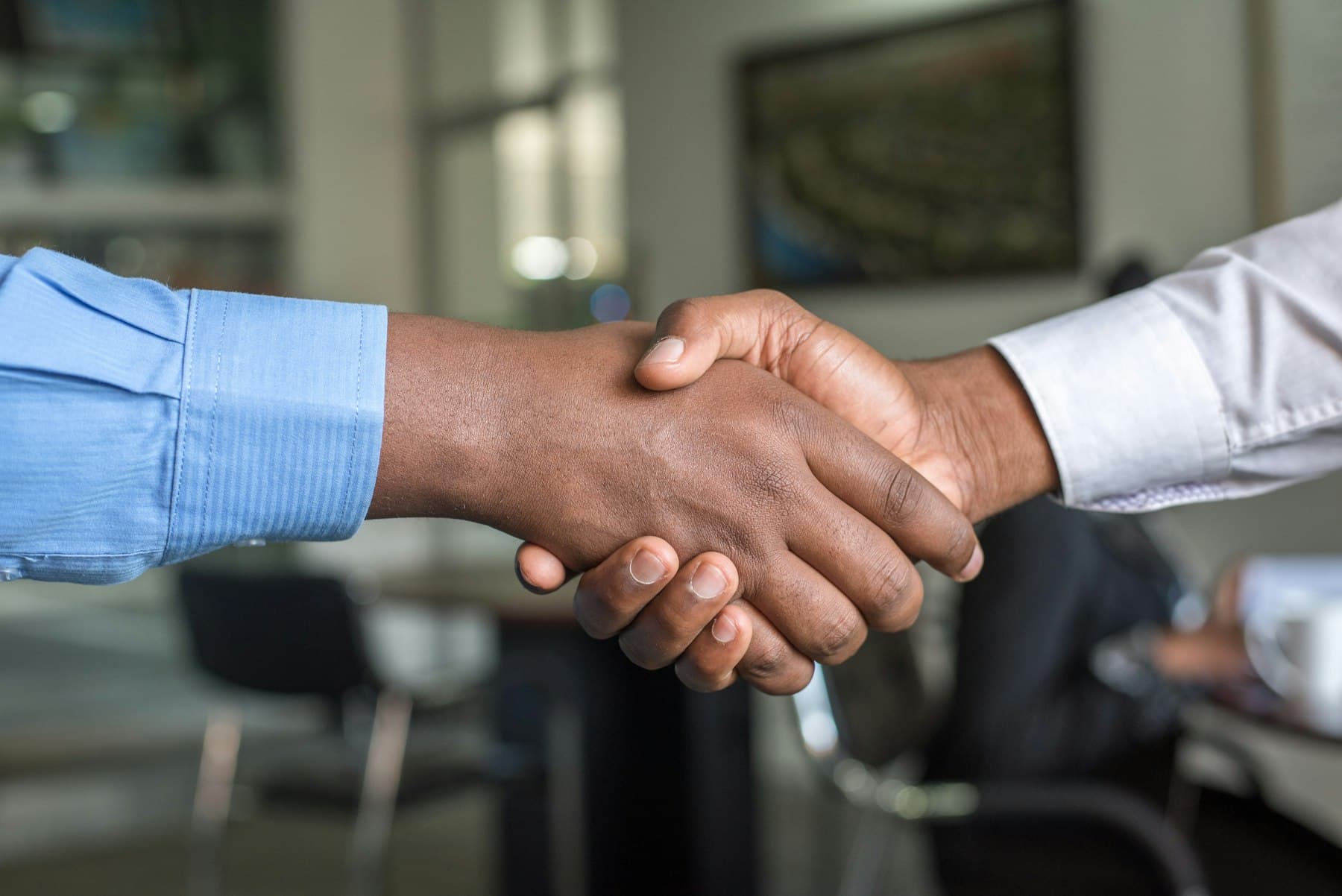 Nahaufnahme eines Händedrucks zwischen zwei Geschäftspartnern in einem Büro