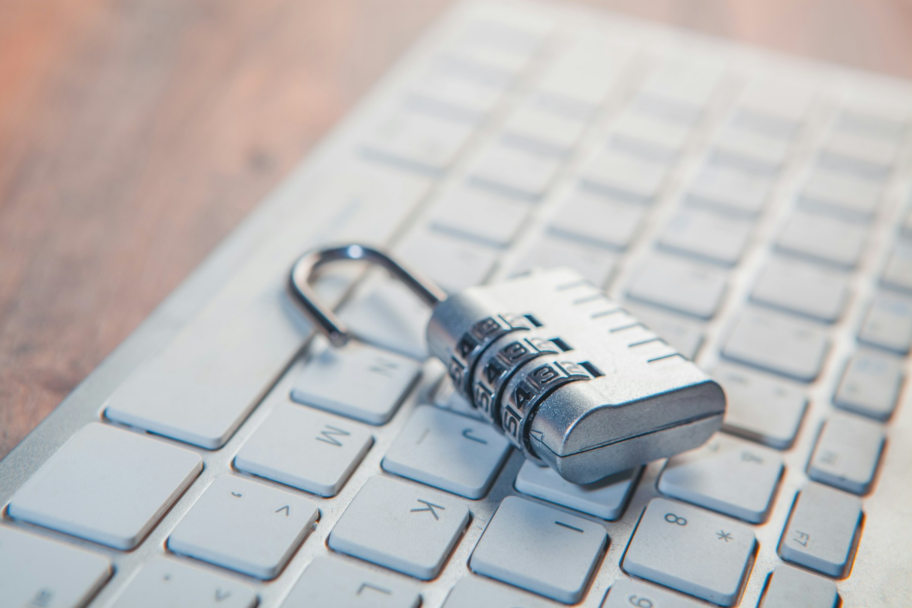 A combination lock rests open on a computer keyboard, symbolizing data security